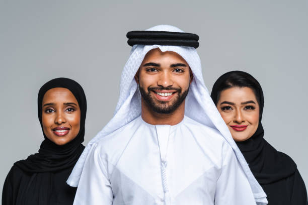 Three professionals in traditional attire stand together, representing the Ajman Free Zone business community.